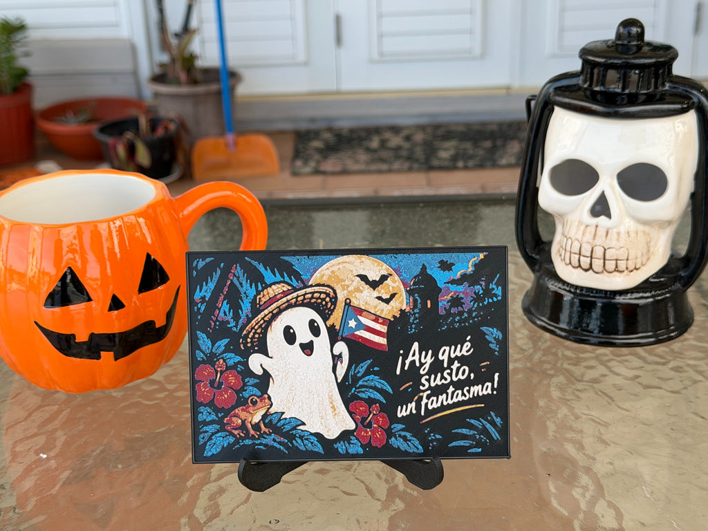 ¡Ay qué susto, un fantasma! Halloween art print on a display stand; pumpkin mug and skull lantern are photo props